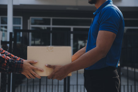 Startup small business entrepreneur of freelance Asian woman using a laptop with box Cheerful success Asian woman her hand lifts up online marketing packaging box and delivery SME idea conceptの写真素材