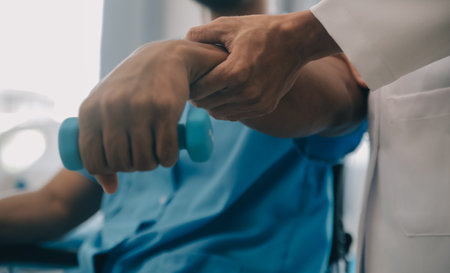 Doctor or Physiotherapist working examining treating injured arm of athlete male patient, stretching and exercise, Doing the Rehabilitation therapy pain in clinic.の写真素材