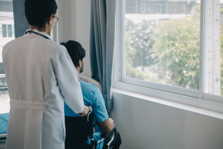 Depressed senior man sitting on the hospital bed alone at night, he feels lonely and abandonedの写真素材