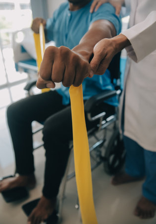 Doctor or Physiotherapist working examining treating injured arm of athlete male patient, stretching and exercise, Doing the Rehabilitation therapy pain in clinic.の写真素材
