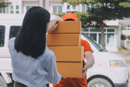 Asian Woman Receiving Product from delivery man at Home, Young Owner Woman Order Product from Smartphone Application, Woman with Online Business or SME Concept.の写真素材
