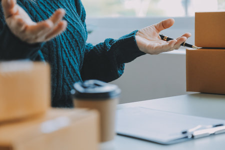 Entrepreneurs Small Business SME Independent men work at home Use smartphones and laptops for commercial checking, online marketing, packing boxes, SME sellers, concept, e-commerce team, online salesの写真素材