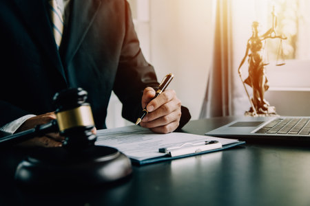 Business and lawyers discussing contract papers with brass scale on desk in office. Law, legal services, advice, justice and law concept picture with film grain effectの写真素材