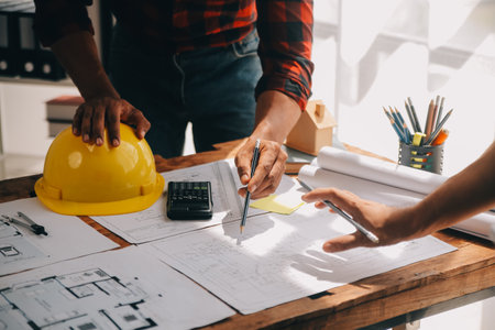 Close up of civil male engineer asian working on blueprint architectural project at construction site at desk in office.の写真素材