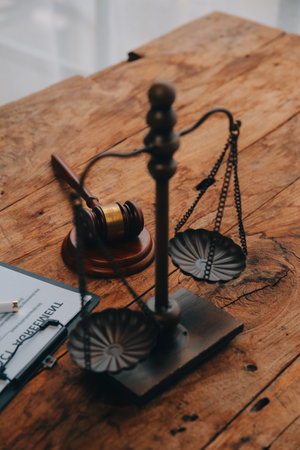 Justice and Law concept. Legal counsel presents to the client a signed contract with gavel and legal law or legal having team meeting at law firm in backgroundの写真素材