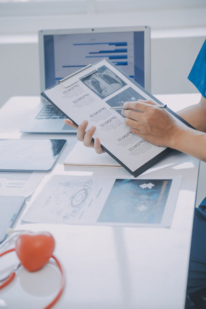 Multiracial medical team having a meeting with doctors in white lab coats and surgical scrubs seated...