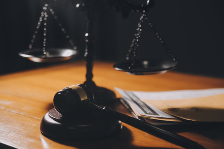 law books and scales of justice on desk in library of law firm. jurisprudence legal education...