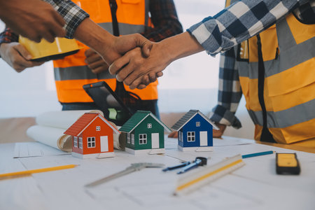 Construction and structure concept of Engineer or architect meeting for project working with partner and engineering tools on model building and blueprint in working site, contract for both companies.の写真素材