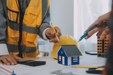 Construction and structure concept of Engineer or architect meeting for project working with partner and engineering tools on model building and blueprint in working site, contract for both companies.の写真素材