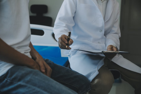Doctor or physical therapist examines back pain and spinal area to give advice within the rehabilitation center.の写真素材