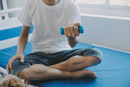 Doctor or physical therapist examines back pain and spinal area to give advice within the rehabilitation center.の写真素材