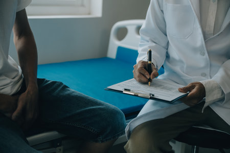 Doctor or physical therapist examines back pain and spinal area to give advice within the rehabilitation center.の写真素材