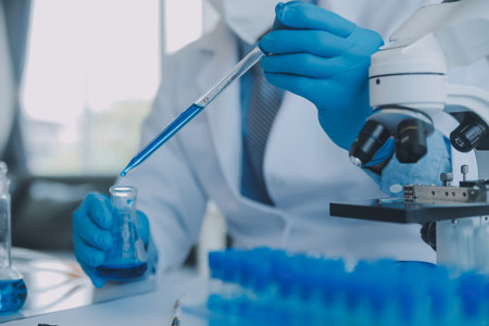biochemical research scientist team working with microscope for coronavirus vaccine development in...