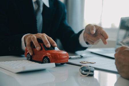 Closeup asian male people car salesman or sales manager offers to sell a car and explains and reads the terms of signing a car contract and insurance.の写真素材