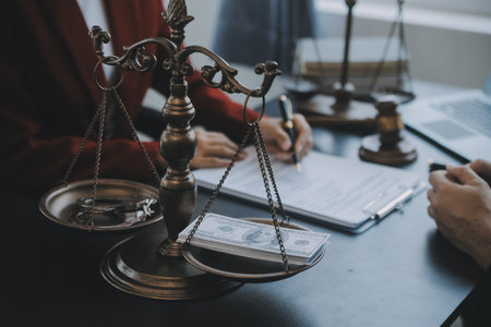 Justice and law concept.Male judge in a courtroom with the gavel, working with, computer and docking keyboard, eyeglasses, on table in morning lightの写真素材