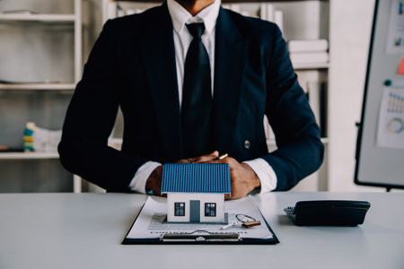 House model with real estate agent and customer discussing for contract to buy house, insurance or loan real estate background.の写真素材