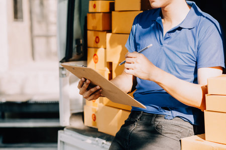 SME entrepreneur Small business entrepreneurs Online selling ideas,Happy Young Asian business owner work on computer and a boxs at home,delivery SME procurement package box deliver to customers,の写真素材