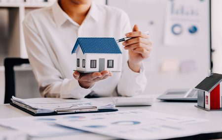 House model with real estate agent and customer discussing for contract to buy house, insurance or loan real estate background.の写真素材