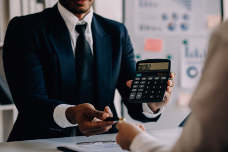 A couple is approaching a housing project to buy, and they are discussing details and advice with a salesperson in a housing project. Real estate trading ideas with couples.の写真素材