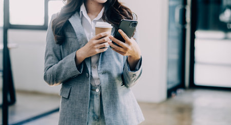 Asian Business woman using calculator and laptop for doing math finance on an office desk, tax, report, accounting, statistics, and analytical research conceptの写真素材
