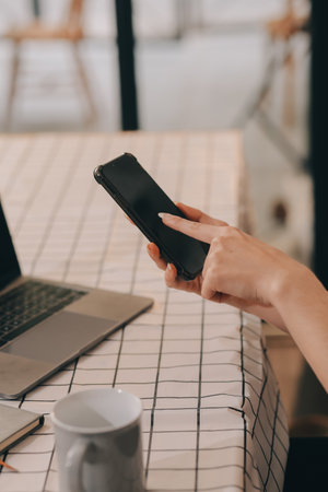Cropped photo of Freelancer business Asian woman holding coffee cup and at doing planning analyzing the financial report, business plan investment, finance analysis the workplace.の写真素材
