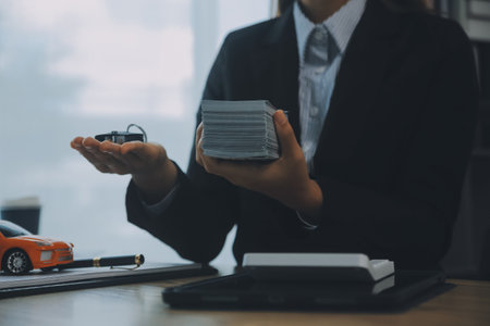 Salesman send key to customer after good deal agreement, successful car loan contract buying or selling new vehicle.の写真素材