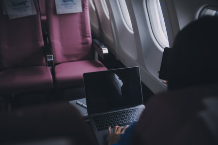 Using mobile and laptop, Thoughtful asian people female person onboard, airplane window, perfectly capture the anticipation and excitement of holiday travel. chinese, japanese people.の写真素材
