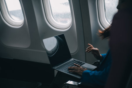 Using mobile and laptop, Thoughtful asian people female person onboard, airplane window, perfectly capture the anticipation and excitement of holiday travel. chinese, japanese people.の写真素材