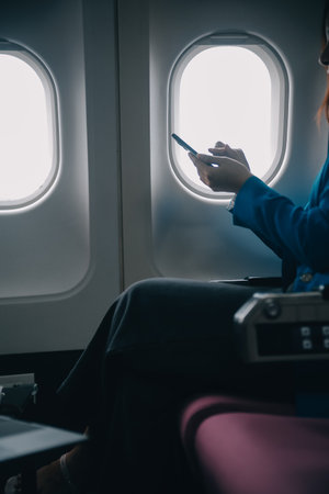 Using mobile and laptop, Thoughtful asian people female person onboard, airplane window, perfectly...
