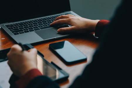 Corporate Communication. Asian Businesswoman Talking On Mobile Phone Working On Laptop In Modern Office. Free Spaceの写真素材