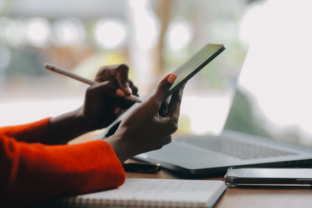 Portrait of Young Asian woman hand freelancer is working her job on computer tablet in modern office. Doing accounting analysis report real estate investment data, Financial and tax systems concept.の写真素材
