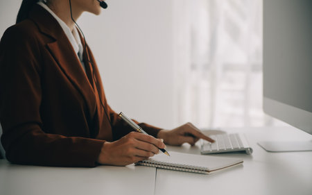 Young friendly operator woman agent with headsets working in a call centre.の写真素材
