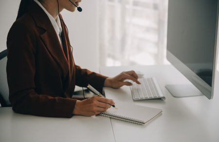 Young friendly operator woman agent with headsets working in a call centre.の写真素材