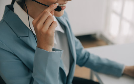Beautiful female call center operator working on computer in officeの写真素材