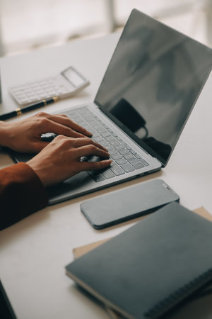 Close up Business woman using calculator and laptop for do math finance on wooden desk, tax, accounting, statistics and analytical research conceptの写真素材