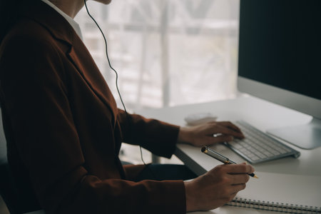 Beautiful female call center operator working on computer in officeの写真素材