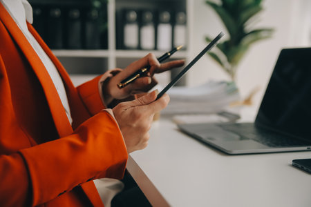 Close up Business woman using calculator and laptop for do math finance on wooden desk, tax, accounting, statistics and analytical research conceptの写真素材
