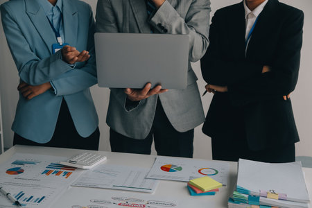 Financial analysts analyze business financial reports on a digital tablet planning investment project during a discussion at a meeting of corporate showing the results of their successful teamwork.の写真素材