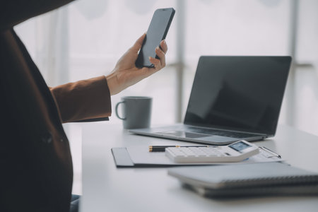 Portrait of Young Asian woman hand freelancer is working her job on computer tablet in modern office. Doing accounting analysis report real estate investment data, Financial and tax systems concept.の写真素材