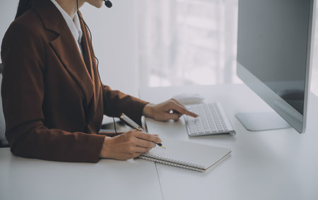 Beautiful female call center operator working on computer in officeの写真素材