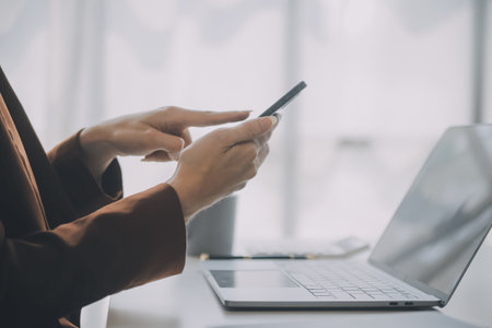 Portrait of Young Asian woman hand freelancer is working her job on computer tablet in modern office. Doing accounting analysis report real estate investment data, Financial and tax systems concept.の写真素材