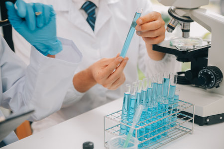 Scientist or medical in lab coat working in biotechnological laboratory, Microscope equipment for research with mixing reagents in glass flask in clinical laboratory.の写真素材