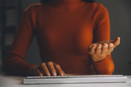 Asian Businesswoman Using laptop computer and working at office with calculator document on desk, doing planning analyzing the financial report, business plan investment, finance analysis concept.の写真素材