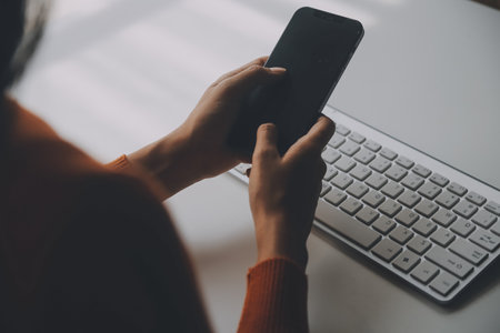 Asian Businesswoman Using laptop computer and working at office with calculator document on desk, doing planning analyzing the financial report, business plan investment, finance analysis concept.の写真素材