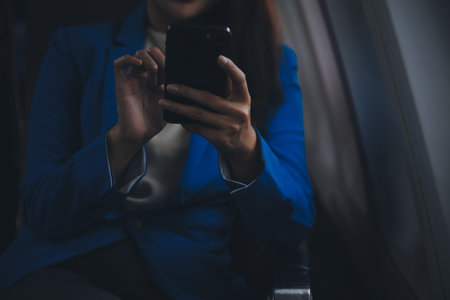 Young Asian business woman talking on smartphone, businesswoman working while flying at plane, Young...