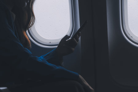 Using mobile and laptop, Thoughtful asian people female person onboard, airplane window, perfectly capture the anticipation and excitement of holiday travel. chinese, japanese people.の写真素材