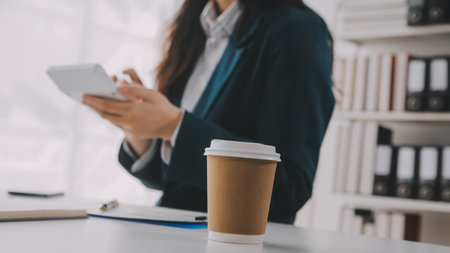Businessman using a calculator to calculate numbers on a company's financial documents, he is analyzing historical financial data to plan how to grow the company. Financial concept.の写真素材