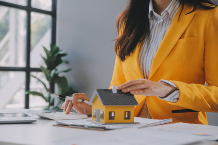 real estate agent Delivering sample homes to customers, mortgage loan contracts. Make a contract for hire purchase and sale of a house. and home insurance contracts, home mortgage loan conceptsの写真素材