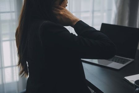 Asian Businesswoman Using laptop computer and working at office with calculator document on desk, doing planning analyzing the financial report, business plan investment, finance analysis concept.の写真素材