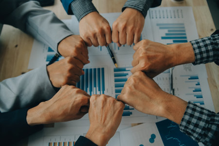 Financial analysts analyze business financial reports on a digital tablet planning investment project during a discussion at a meeting of corporate showing the results of their successful teamwork.の写真素材